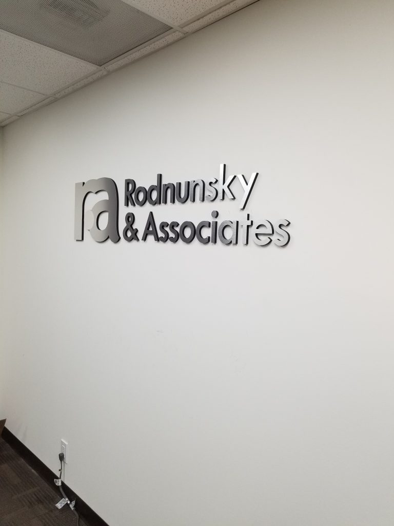 Our law firm lobby sign for Rodnunsky and Associates composed of  laser cut black acrylic with brushed metal lettering and polished metal.