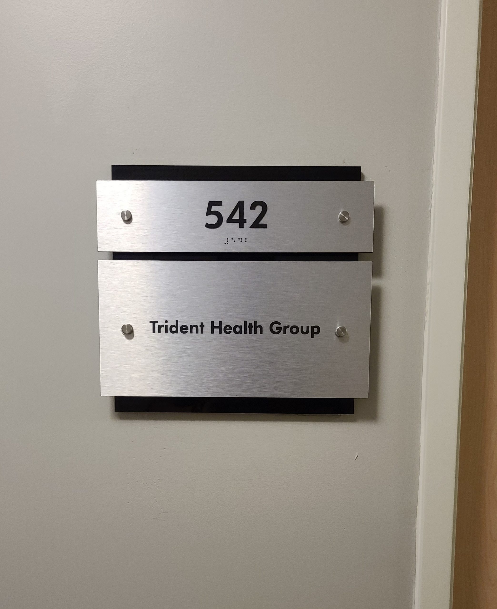 We fabricated and installed this suite door plaque for Ethan Christopher's property. It has tactile numbers and braille making it ADA-compliant.