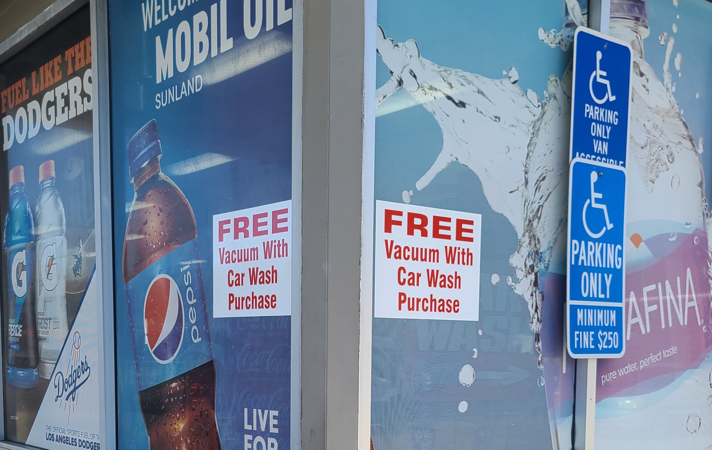 The advertisement window stickers for Mobil Express Car Wash in Sunland promotes their free vacuum service after every car wash.
