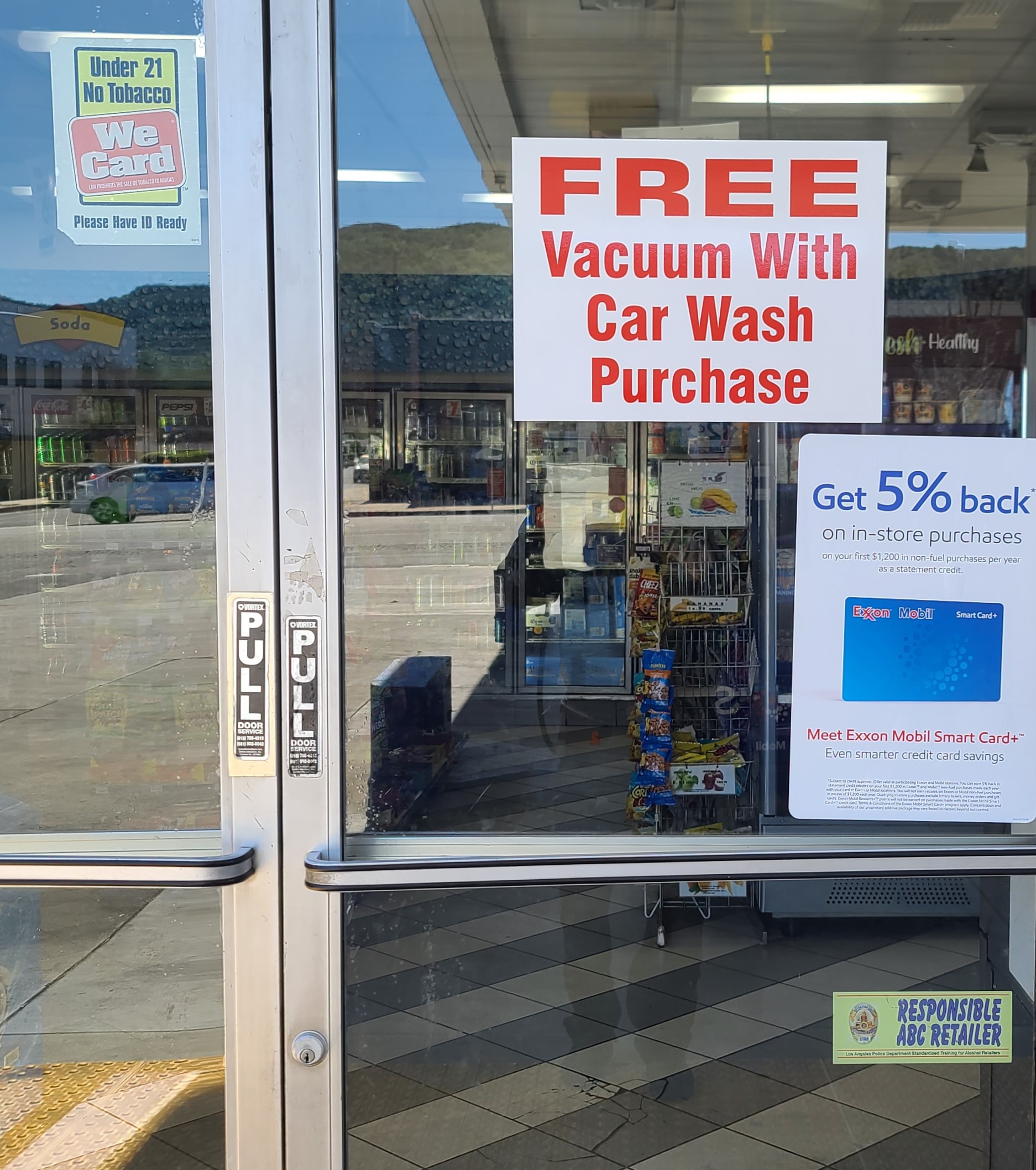 The advertisement window stickers for Mobil Express Car Wash in Sunland promotes their free vacuum service after every car wash.