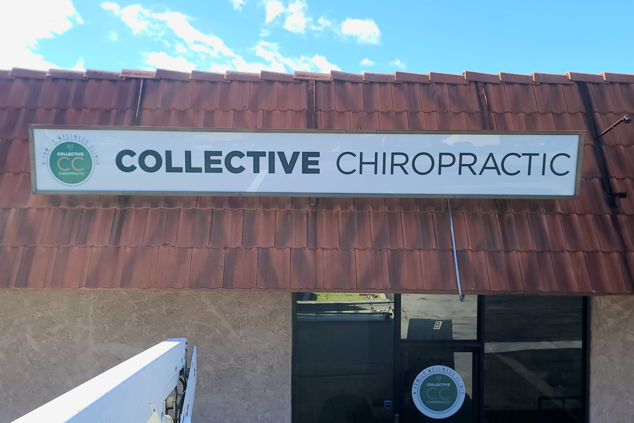 Vibrant lightbox sign promoting Collective Chiropractor