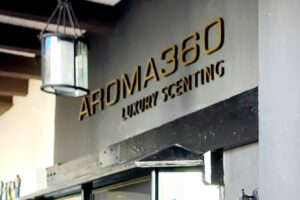 Aroma 360 Outdoor Sign - Smaller outdoor sign in brushed light brass displaying LUXURY SCENTING.