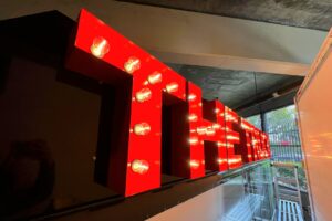 Channel Letters Craftsmanship - Precision CNC router cutting, vivid red finish, and fluorescent bulbs in action.