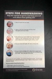 A handwashing safety sign with step-by-step instructions and illustrations.