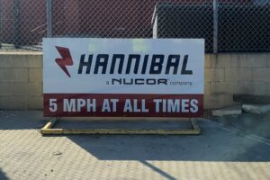 A Dibond sign on a property driveway that says "5 MPH AT ALL TIMES."