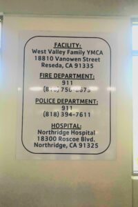A YMCA safety signage that shows the location of the facility, fire department, police department, and hospital.