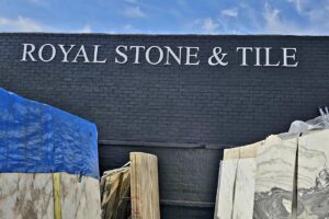 A photo showcasing the entire "Royal Stone & Tile" sign mounted on a building facade. The dimensional letters stand out prominently, adding depth and professionalism to the company's presence.