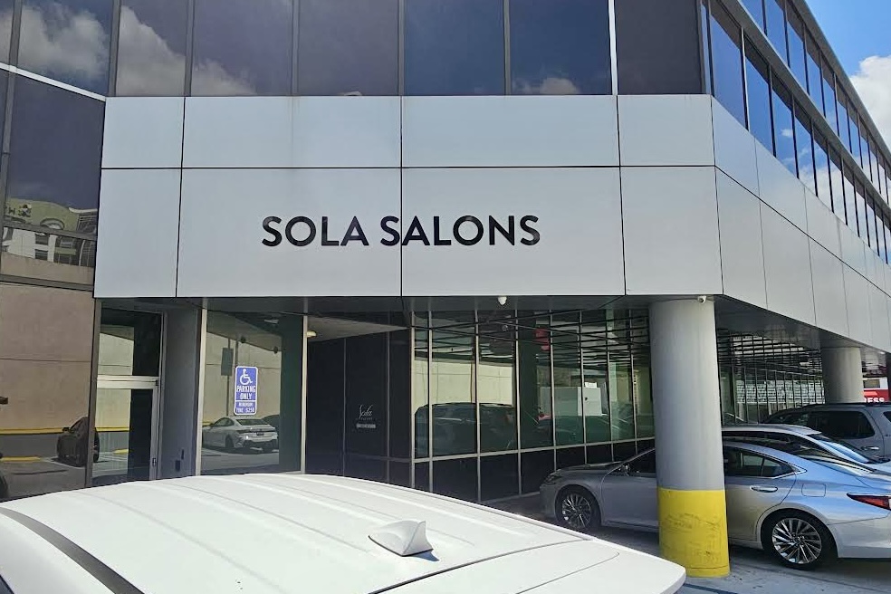 Black dimensional letters spelling out "Sola Salons" mounted above a storefront entrance in Burbank, California