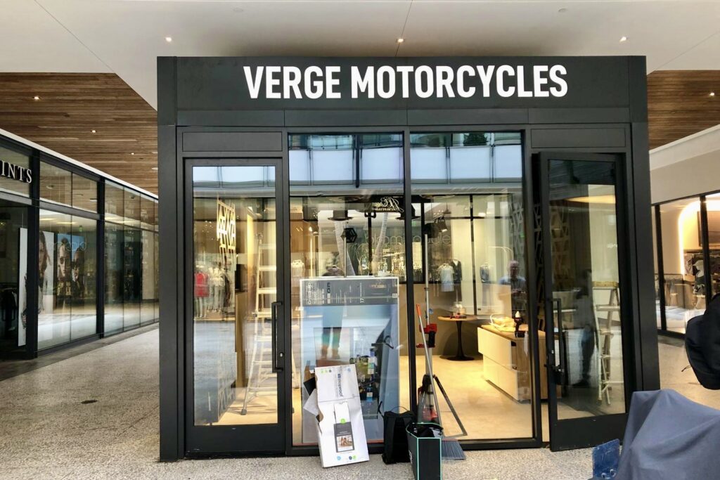 A photo of the store front with dimensional letter sign above the door. The image highlights the crisp lines and smooth finish of the white acrylic material.
