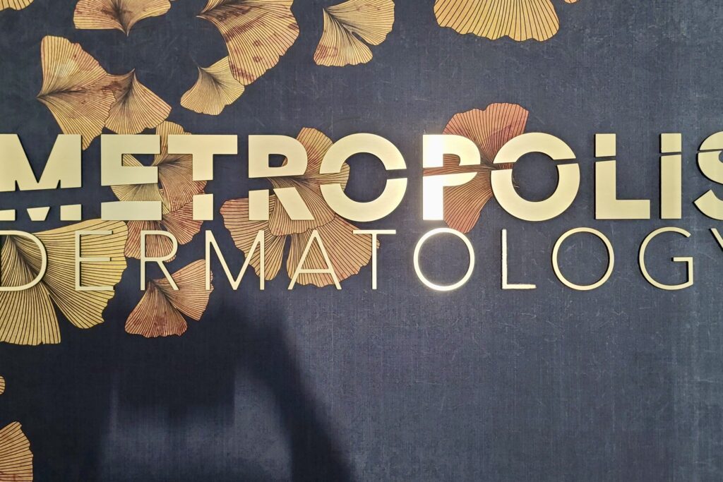 Lobby sign for Metropolis Dermatology in brushed gold acrylic by Los Angeles sign maker Premium Sign Solutions.