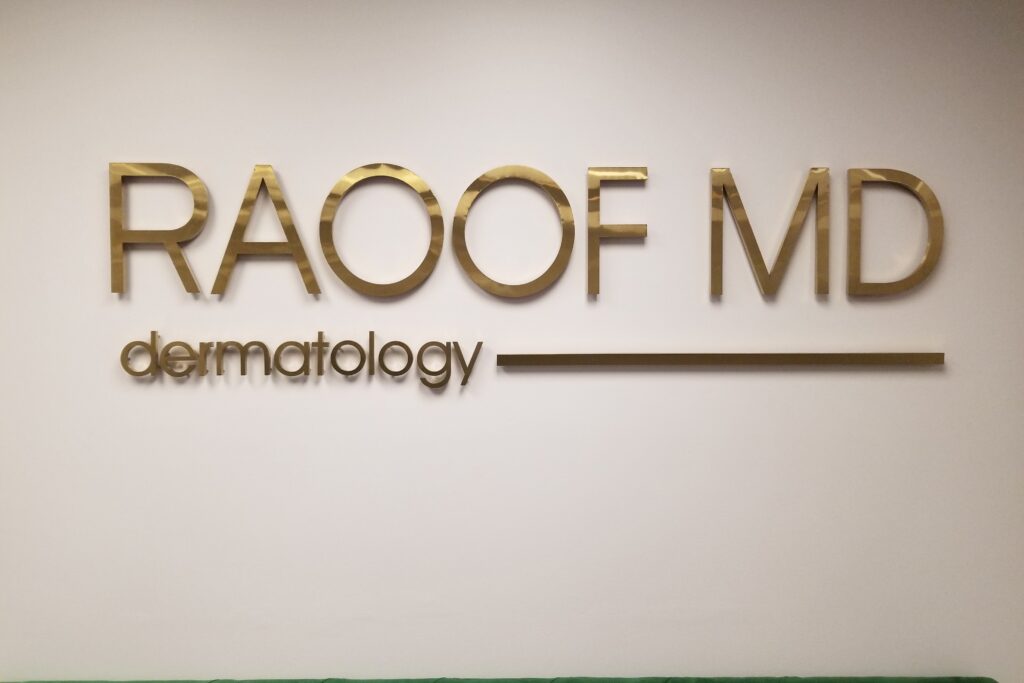 Lobby sign for Raoof MD Dermatology in gold painted acrylic by Los Angeles sign maker Premium Sign Solutions