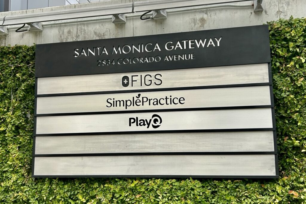 A wide shot of the Simple Practice outdoor sign mounted on a building exterior, highlighting its prominent size and pierced cut lettering.