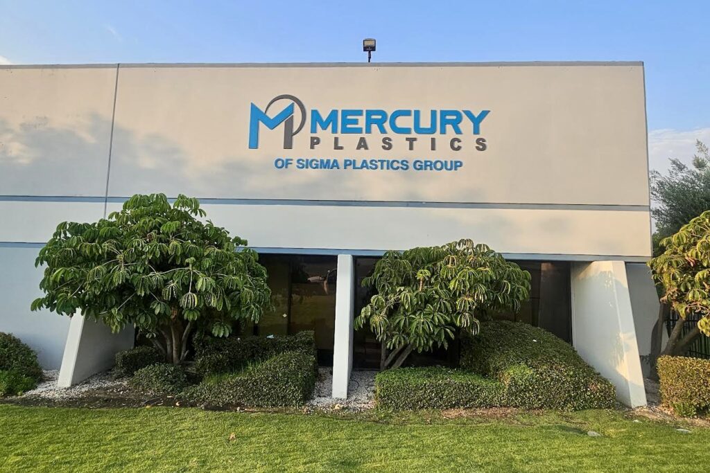 A wide shot of the Mercury Plastics building showcasing the massive main sign with prominent lettering and the integrated logo.
