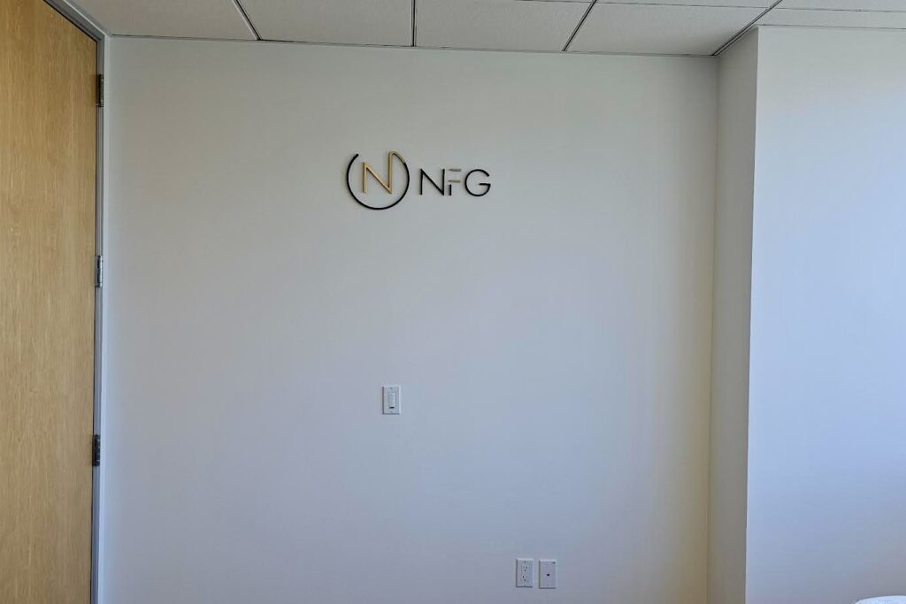 Check out this awesome wide shot of the big NFG logo sign on the wall. It's huge and the brushed gold finish really makes it stand out!