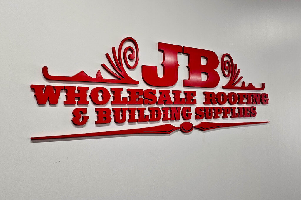 A close shot of the JB Wholesale interior with the relocated signage prominently displayed. The sign is clearly visible, creating a strong presence for the company