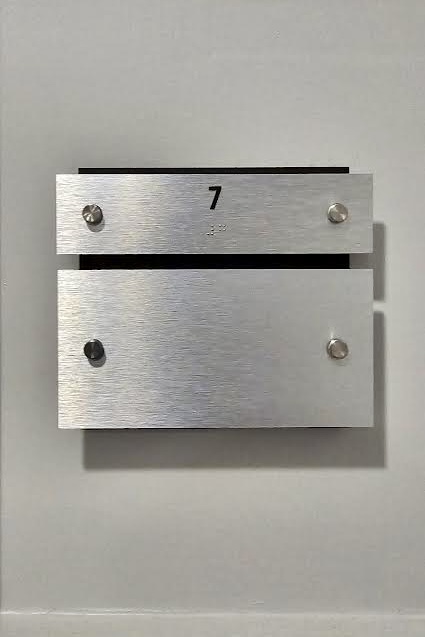 A close-up view of a standard suite plaque. The plaque features the same design as the penthouse suite plaque, but the unit number is different.
