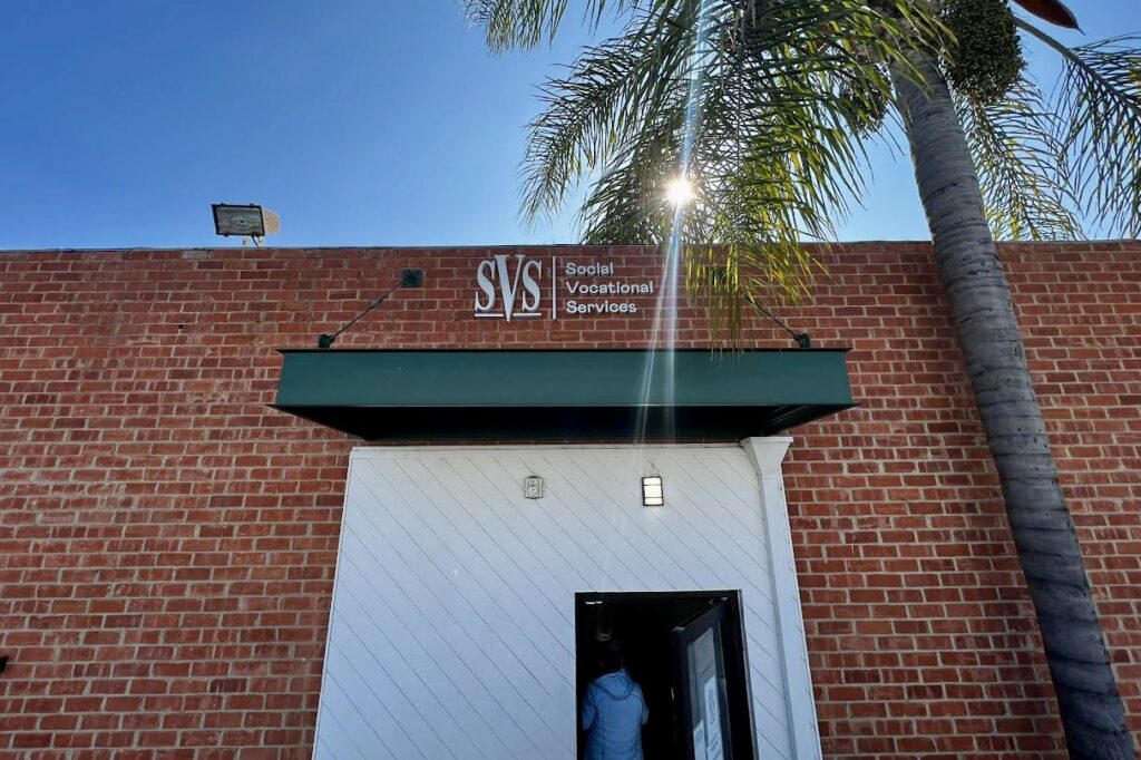 Wide shot of a fabricated stainless steel sign spelling out “Social Vocational Services” in raised dimensional letters. (Whittier location)
