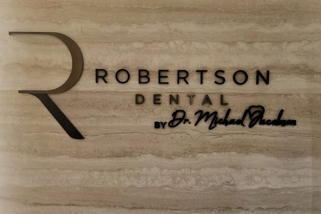 Sleek and modern lobby sign for Robertson Dental, featuring a prominent "R" logo and elegant typography.