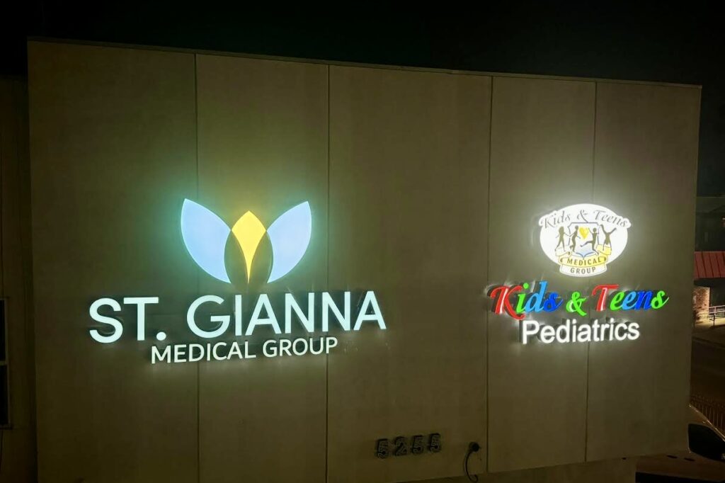 Night shot of custom outdoor signs in Los Angeles medical centers. These illuminated channel letter signs for St. Gianna Medical Group and Kids & Teens Pediatrics with LED lighting attract eyes.
