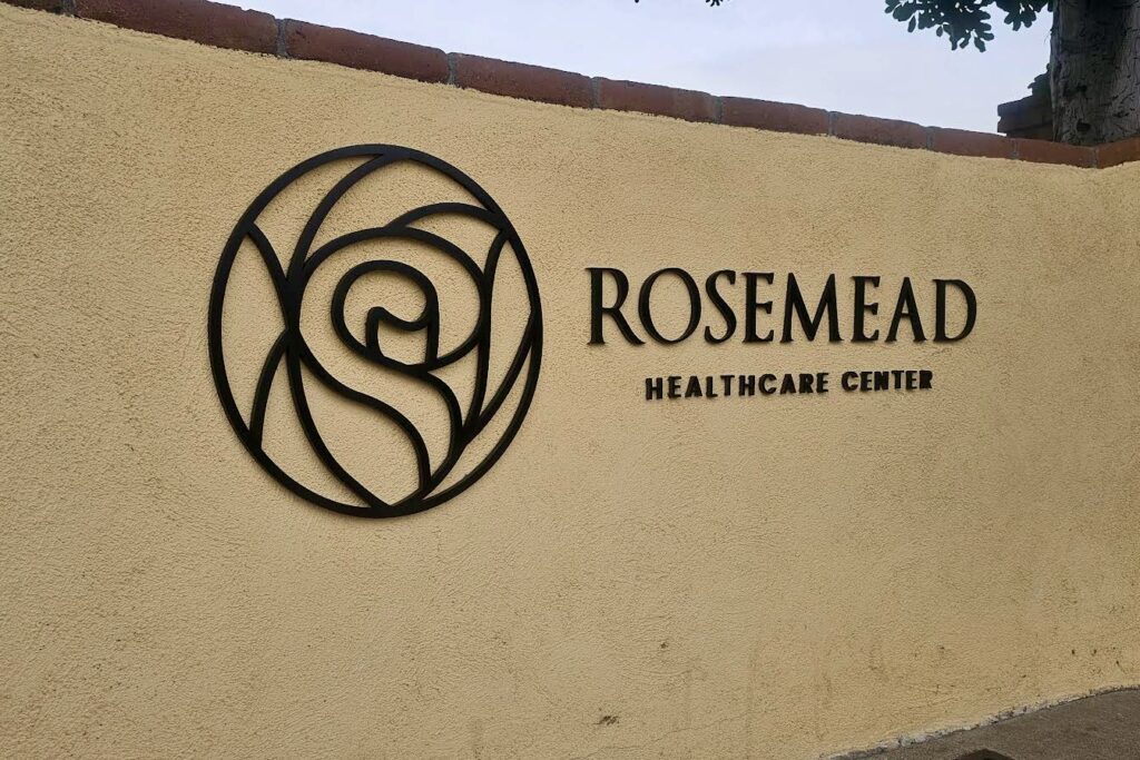 A wide shot of a parking lot at an El Monte medical complex, featuring a large pole-mounted sign with the clinic’s logo and name in bold, UV-protected vinyl. The design prioritizes legibility under sunlight, reinforcing brand presence for arriving patients.