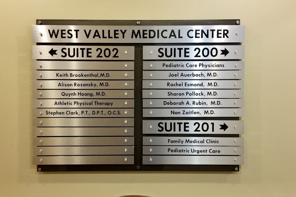 Photo of a brushed metal directory sign for West Valley Medical. Marketing wayfinding for medical rooms. 