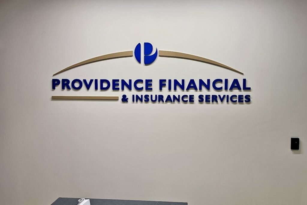 A financial services sign a Dimensional lobby sign for Providence Financial & Insurance Services featuring bold blue text and curved gold accent bar.