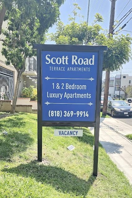 Custom apartment signage with double-sided lusterboard finish and black frame