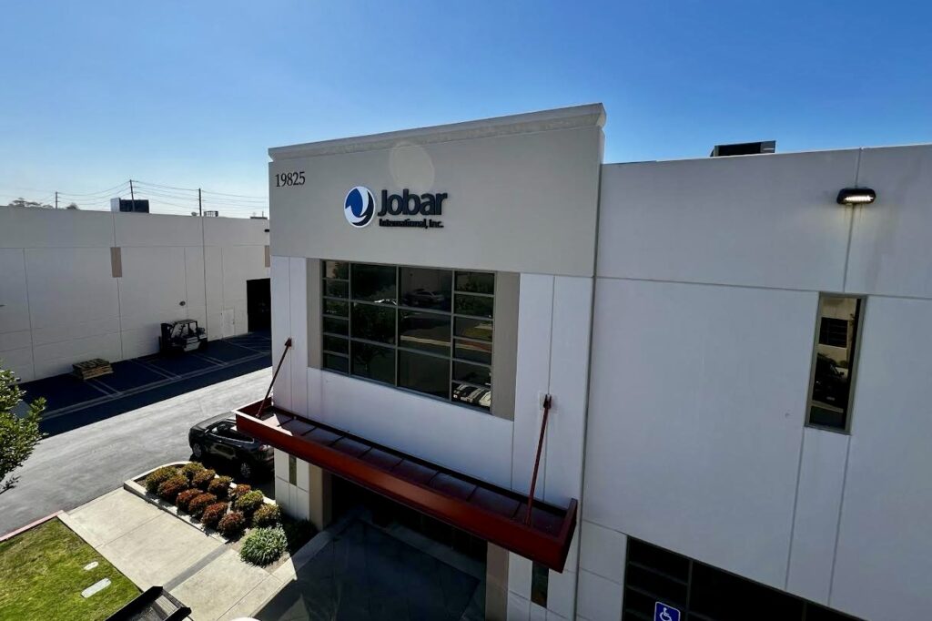 High-angle shot of Jobar International, Inc., highlighting its corporate signage in Torrance. The red awning and address 19825 stand out against the modern facade.