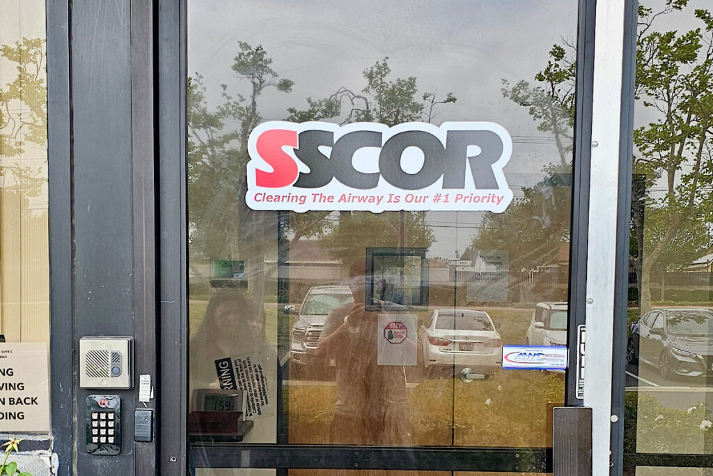 Vinyl door decal featuring SSCOR logo and white cloud design for controlled-access medical facility entrance