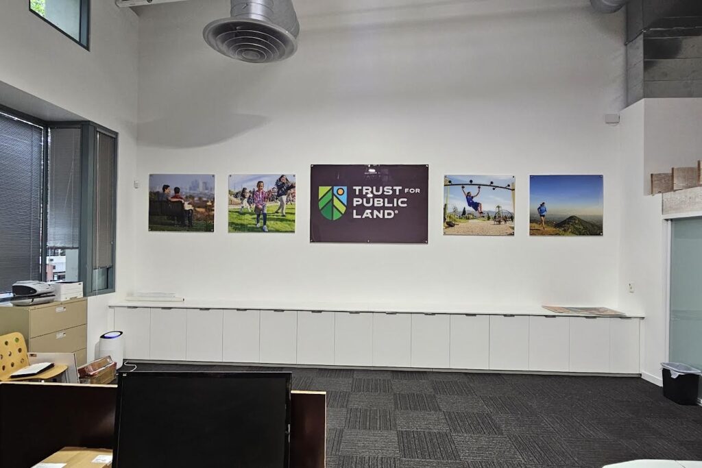 Reception signage between project photos as branding signage for non profits Trust for Public Land.