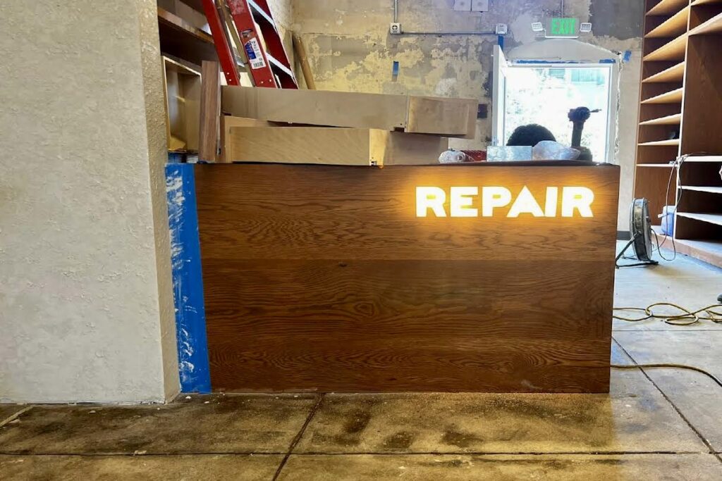 A view on Veja Venice repair desk illuminated retail sign. Part of their retail signage package.