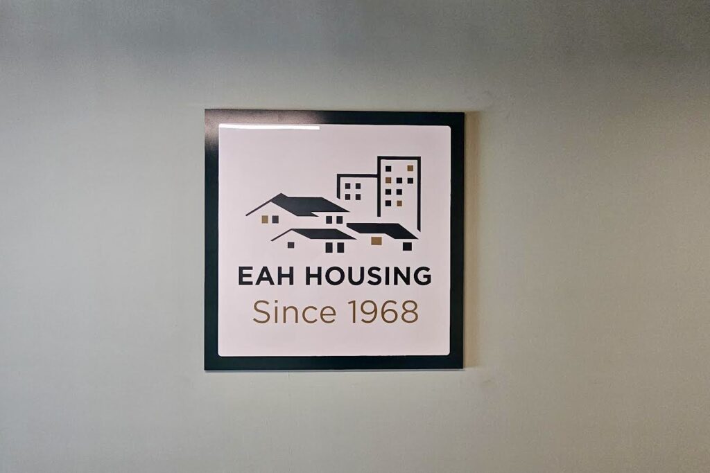 Close-up of layered acrylic office sign featuring Pantone green and vinyl artwork
