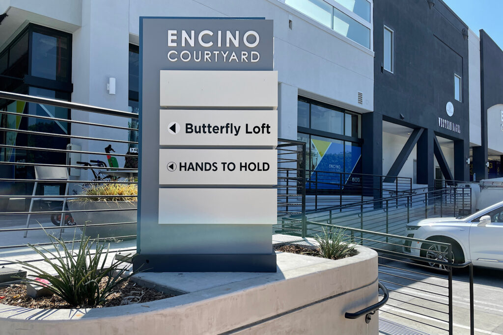 Vinyl on a pavement monument sign at Encino Courtyard for Hands to Hold